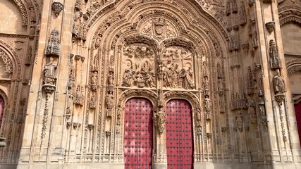 filming of one of the doors of the new cathedral of Salamanca 16th century, seeing the red doors and ascending we see its flamboyant Gothic style ornamentation carved in the typical yellow sandstone