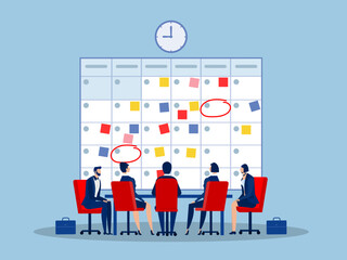 Time management, planning for team concept.Company business team working together planning and scheduling their operations agenda on a big spring desk calendar.