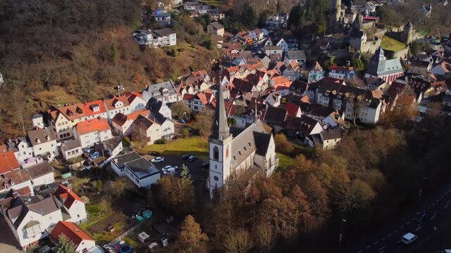 Drone footage of Eppstein Castle and medieval old town in Germany at sunrise. The serene morning light highlights historic architecture of castle and medieval town of Europe. Shots: Parallax
