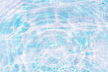 Blue water with ripples on the surface. Defocus blurred transparent blue colored clear calm water surface texture with splashes and bubbles. Water waves with shining pattern texture background.