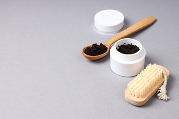 Coffee scrub for the body, in a white jar with a lid, on a gray background.