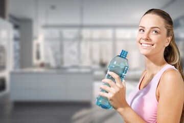 A young pretty woman drinking water at kitchen