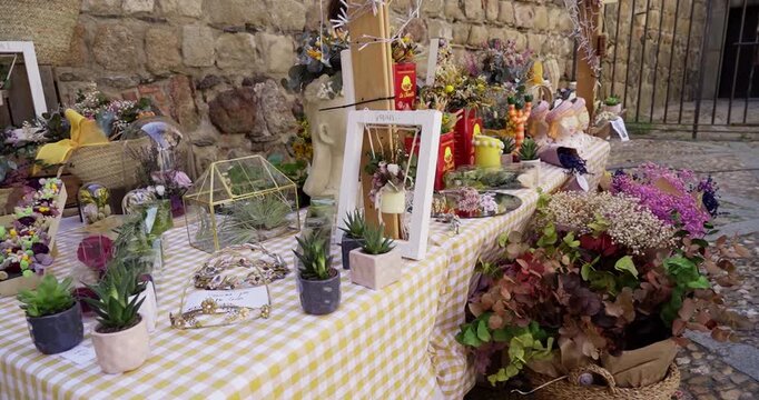 Beautiful general slow motion shot of a rose and decorations flea market stand in Plasencia, Spain during the morning.