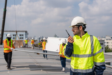 Engineer service check installation solar cell on the roof of factory. Silhouette technician inspection and repair solar cell on the roof of factory. Technology solar energy renewable.