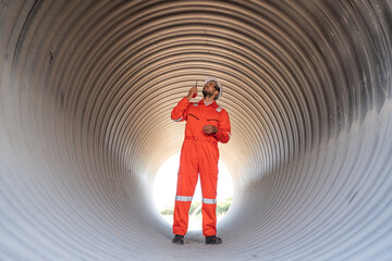 Mechanical engineer wearing safety uniform checking and inspection pipeline system new construction project of industrial.