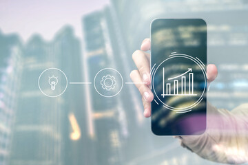 A person is holding a cell phone that has a graph on it