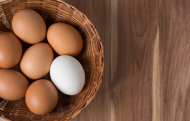 Brown eggs and white eggs are placed in the basket on wooden table, Distinctive white duck eggs, Salted egg. unique and outstanding concept