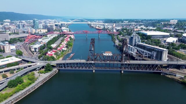 Drone aerial landscape of cars transport travel driving over Johns Steel Bridge crossing Willamette River Burnside Portland Oregon USA America travel tourism city downtown buildings