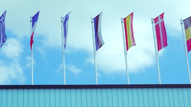 national flags Europe and other countries on satin flutter in wind in blue sky, European Space Agency, state symbols, concept of international cooperation, global business