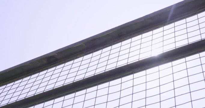 Amazing general slow motion shot of the nets of a soccer field goal backlit by the sun in an empty stadium prior to an important daylight match.