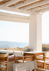 Table with chairs and tables placed in row in modern cafe in Santorini