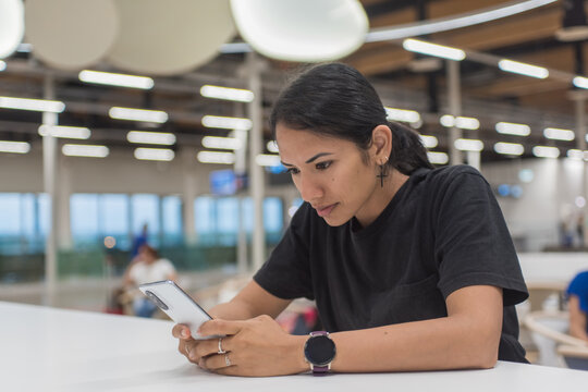 Young woman using smartphone. Scrolling social networks on mobile.