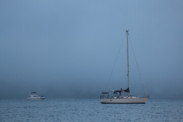 Foggy view of Sailboat on ocean with faint horizon