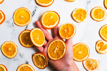 A hand holds dehydrated orange slices
