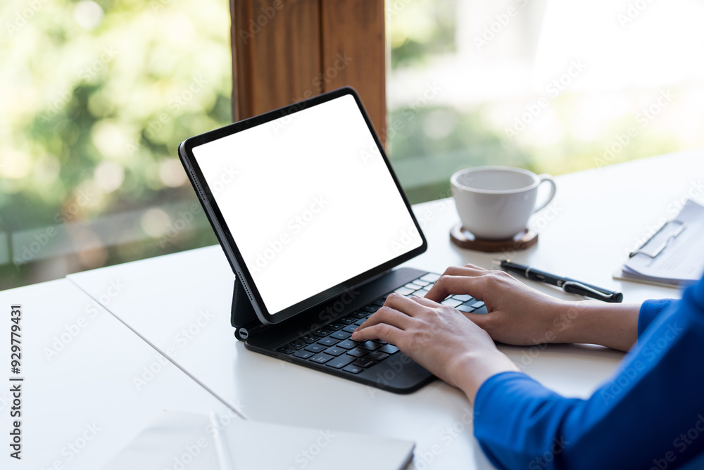 Poster businesswoman typing on a tablet computer with an empty white screen for your advertisement while wo