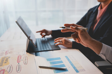 Business team analyzing financial documents using digital tablet during a meeting in modern office