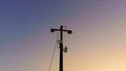 Power electric pole on sunset background