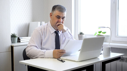 Obraz premium Man Working with Documents at Office Desk