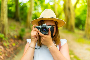 Woman traveler taking photos in the forest