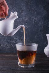 Pouring a rich and velvety Cream into a refreshing Glass of Cold Brew Coffee for that perfect morning sip
