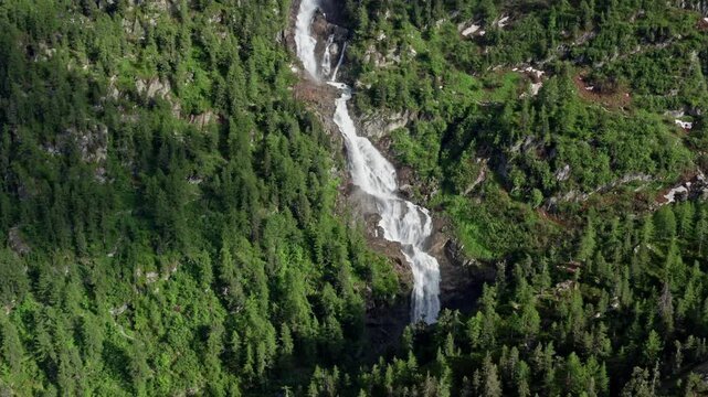 Cascate del Rutor waterfall cascades down lush green mountains in a stunning aerial view