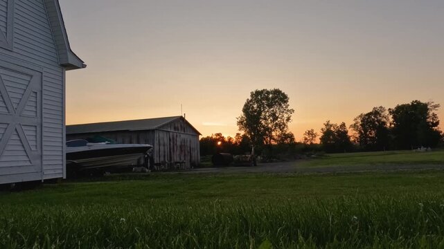 A tranquil morning scene featuring a rustic barnyard as the sun rises, casting a golden hue over the landscape. Ideal for content related to rural life, country living, and peaceful mornings.