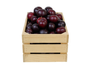 Red plums in wooden box isolated on white background