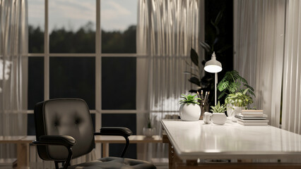 A table and a black leather chair in a contemporary room or office, illuminated by a table lamp