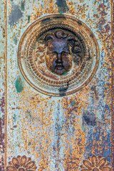 Bas relief of an angel's head on an old rusty church door