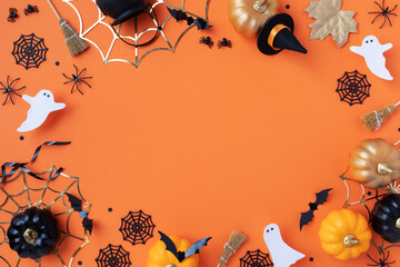 Halloween holiday frame with party decorations from pumpkins, bats, spider web and ghosts top view....