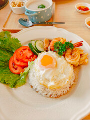 Fried egg on top, seafood stir-fried rice with basil