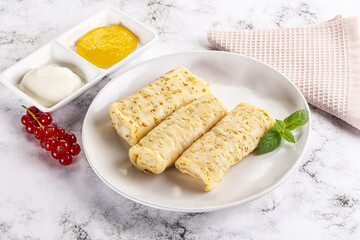 Homemade stuffed pancakes with honey and cream sour