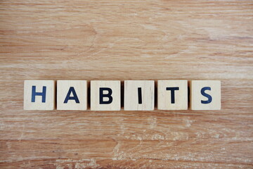 Habits alphabet letters top view on wooden background, health and wellness concept