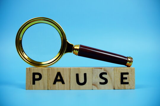Pause with wooden blocks alphabet letters and Magnifying glass on blue background