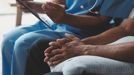 Elderly people are at risk. Female doctor visits her elderly patient at home and provides support and talks to him. Concept of health care and disease prevention.