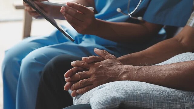 Elderly people are at risk. Female doctor visits her elderly patient at home and provides support and talks to him. Concept of health care and disease prevention.