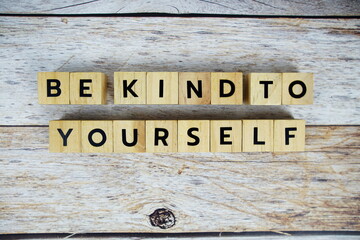 Be Kine To Yourself with wooden blocks alphabet letters on wooden background