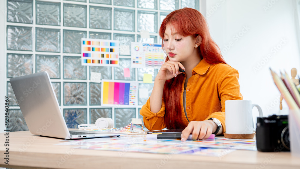 Poster a graphic designer is working in studio, focusing on selecting colors from a set of color swatches.