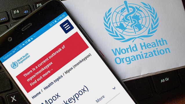 website on a smartphone and Logo of the World Health Organization warning on a current outbreak of mpox caused by the monkeypox virus