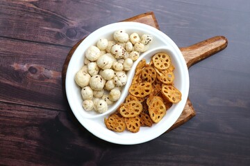 Crispy lotus stem chips and roasted makhana, perfectly spiced and golden brown, offer a delightful crunch and unique flavor. Ideal for healthy snacking or as a gourmet appetizer. kurkuri Kamal kakdi. 