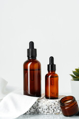 Amber Glass Bottles With Dropper Tops Displayed on a Stone Platform