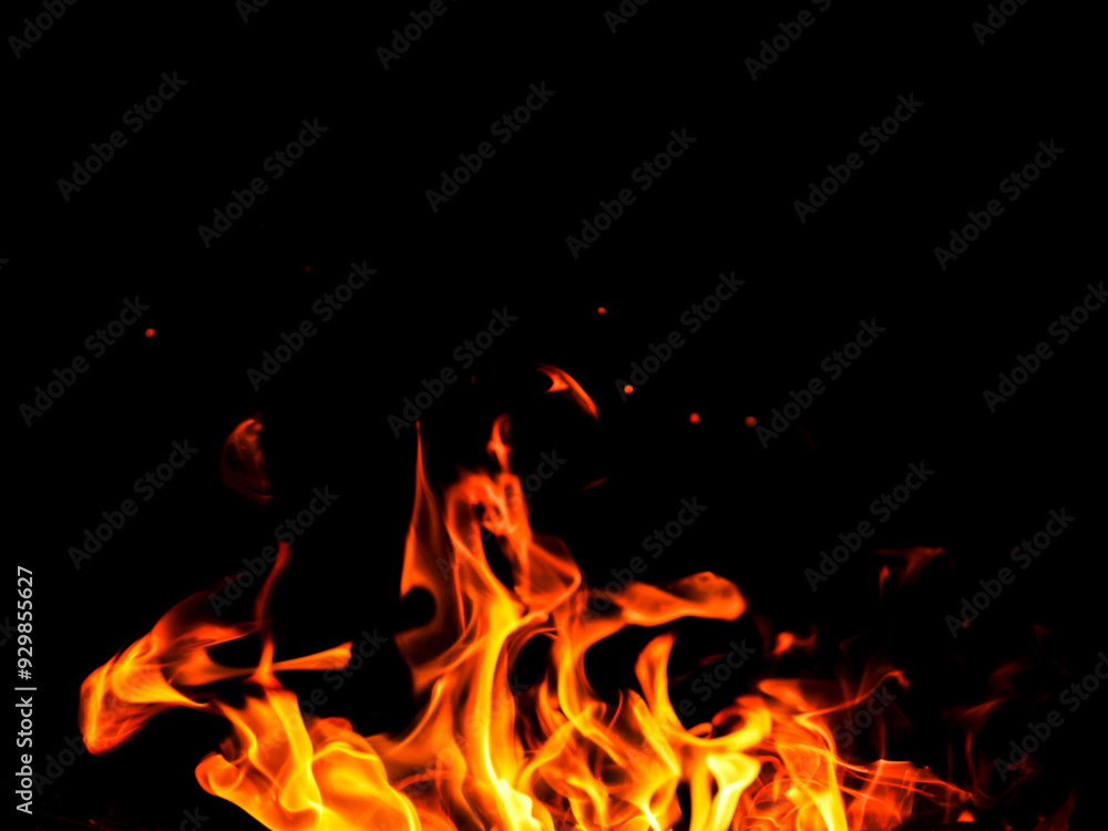 Wall mural a fire is burning in a pile of wood. the fire is orange and yellow, and it is very hot. dark black b