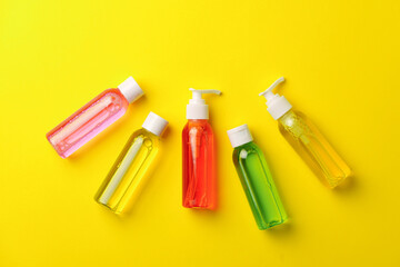 Colorful Bottles of Liquid Soap on Yellow Background