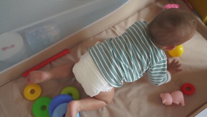 baby crawling first steps. baby toddler gets out of the playpen crib learns to crawl plays. happy...