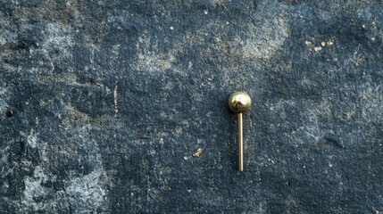 Overhead shot of a pin on a textured background, with room for text, capturing the detail