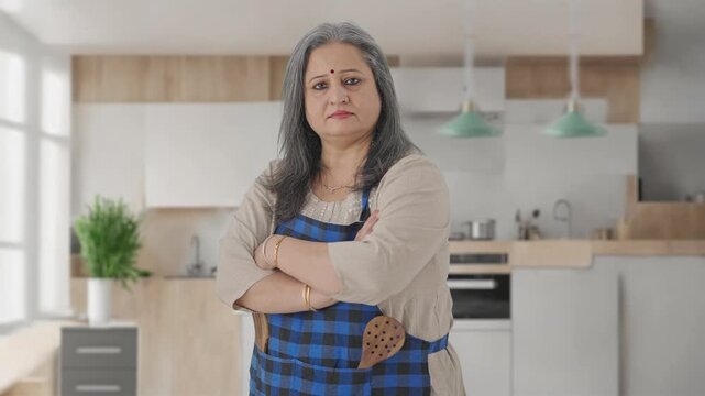 Portrait of Indian aged housewife standing crossed hands