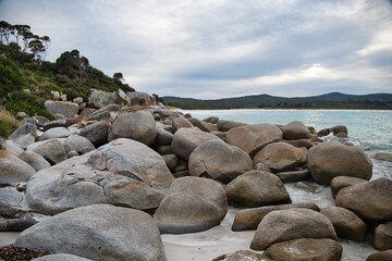 Colorful boulders and rocks on the beach of the 'Bay of Fires' in Tasmania, Australia. Natural wonders of eastern Tasmania. Beautiful coastline of Tasmania. Big round rocks and stones on the beach. 