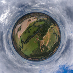 Panoramic view from drone, green little planet and blue sky around the globe