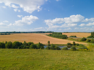 Fototapeta premium Drone view of the highway road, forest and fields, top view and blue sky