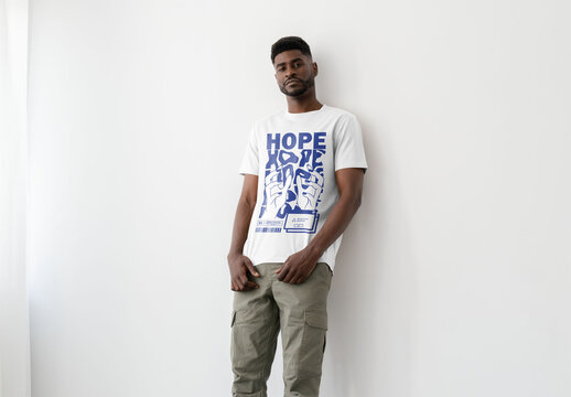 Mockup Of Man In Customized T-Shirt Against Wall In Studio